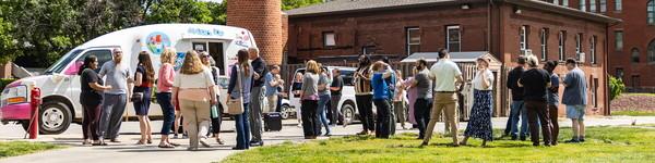 Faculty and staff gather around an ice cream truck outside.